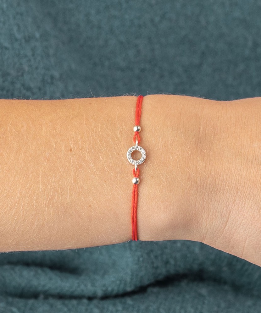 Браслет из красной нити с серебряной подвеской и цирконы