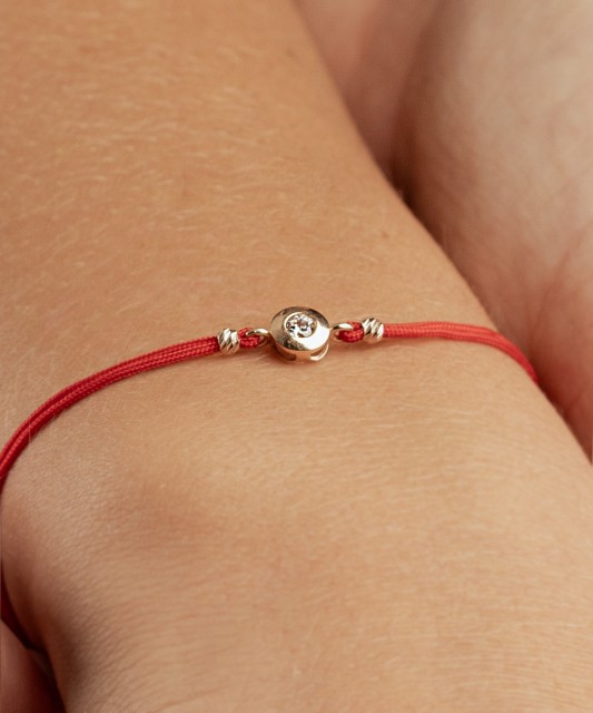 Sarkanas diega aproce ar zelta cirkoniem piekariņu