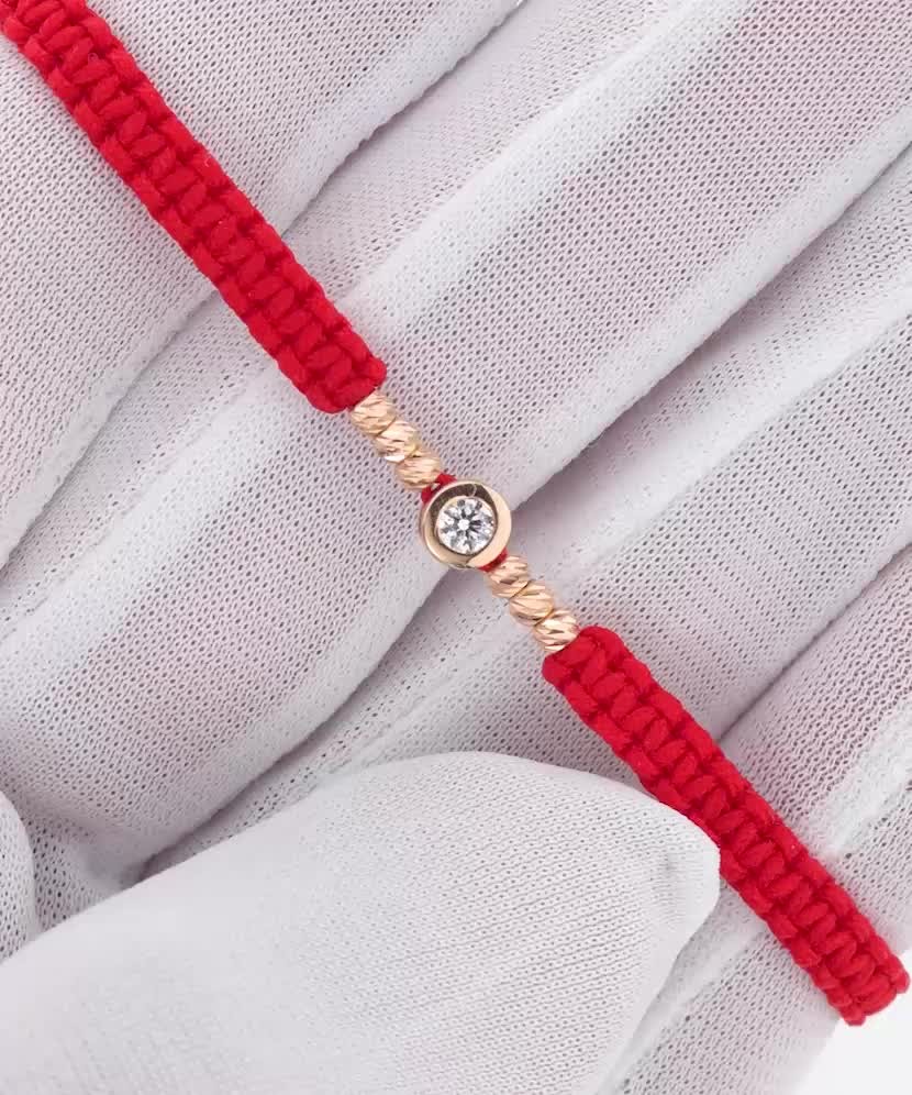 Sarkanas diega aproce ar zelta cirkoniem piekariņu